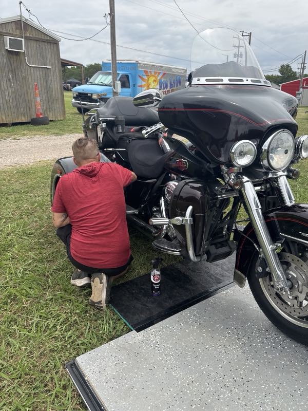 Detailing a black Harley-Davidson motorcycle by hand