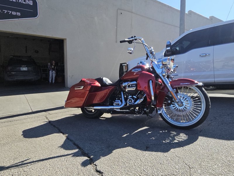 Shined-up red Harley-Davidson Road King outside the shop